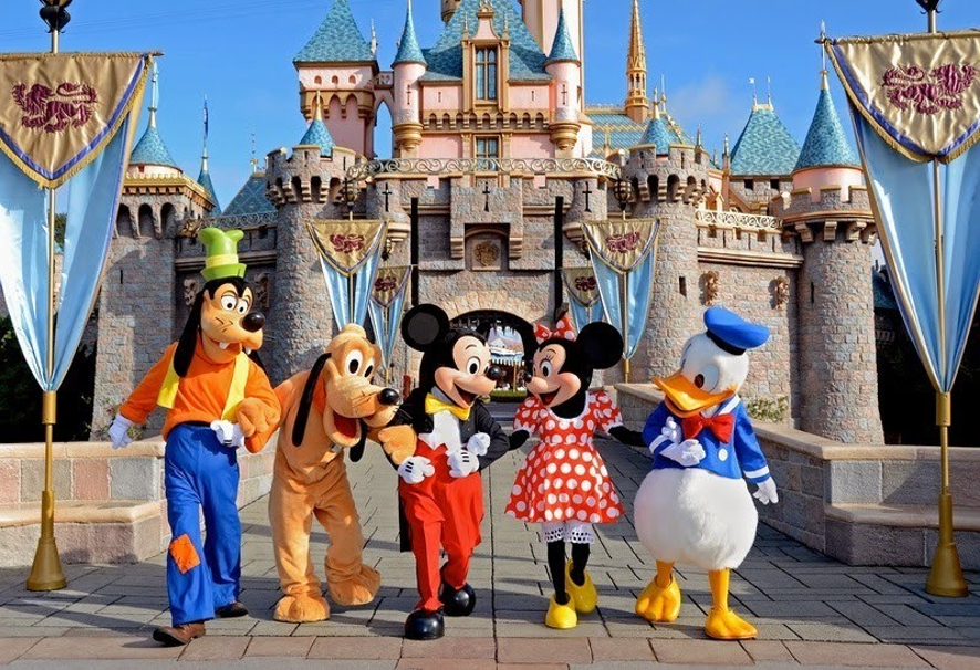 imagem do castelo da Disney com os personagens pluto pateta, mickey, minnie e pato donald na frente